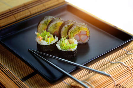 sushi roll on a black plate ready to be servedの写真素材