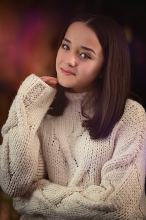 Portrait of a young brunette girl in a white sweaterの写真素材