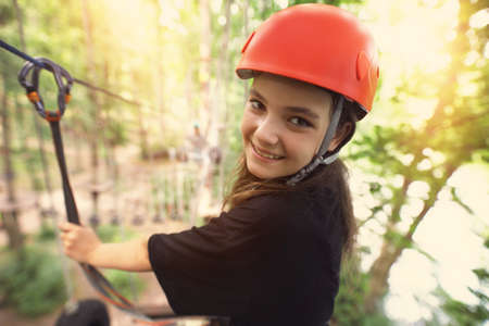 teenage girl on a rope park on a beautiful sunny dayの写真素材