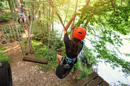 teenage girl on a rope park on a beautiful sunny dayの写真素材