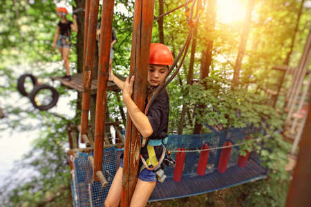 teenage girl on a rope park on a beautiful sunny dayの写真素材