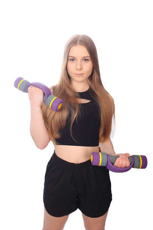 Young girl in fit outfit with dumbbellsの写真素材