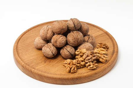 Walnuts on wood plate with white backround
