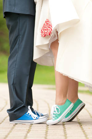 Bride and groom in gym shoes with lollipoppの写真素材