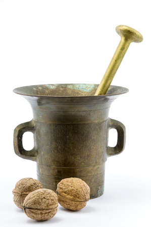 Bronze mortar with walnuts on isolated white backgroundの写真素材