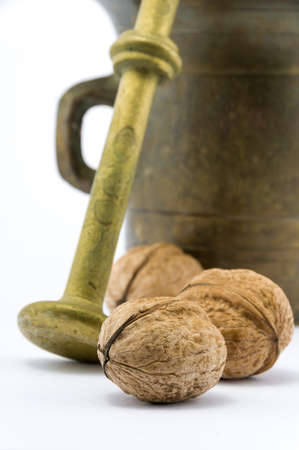 Bronze mortar with walnuts on isolated white backgroundの写真素材