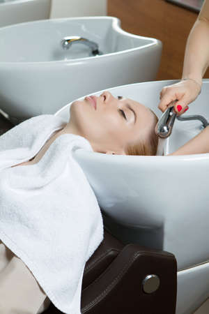 Hairdresser washing hair at beauty salon verticalの写真素材