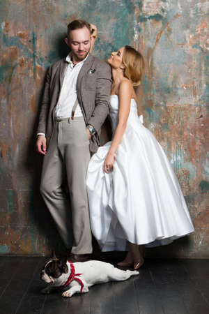 A young bride and groom standing together with dogの写真素材