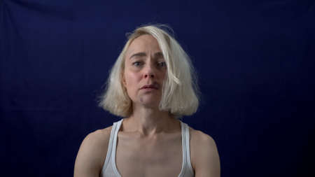 The bruised blonde looks directly at the camera. Violence against women. Sexual harassment.の写真素材