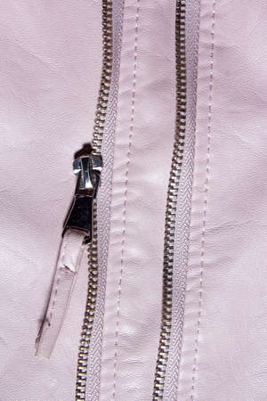 Pink leather background with zipper from the lock. Structured background design leather. A place for text or a logo. Ladys Pink leather jacket.の写真素材