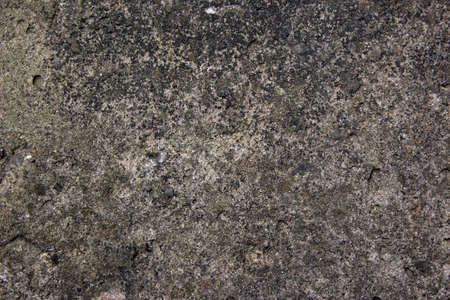 Muddy concrete wall with cracks and black spots. Old and dirty tested wall background. Architecture and construction works. Close-up old weathered concrete texture of the wall.の写真素材