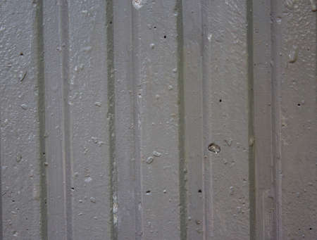 Corrugated sheet metal, badly painted with grey paint for background. Metal corrugated roofing sheet. Painting of metal surfaces for rust control. Abstract background for sites and layouts.の写真素材