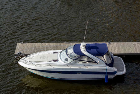Pier speedboat. A marina lot. Yacht is moored at the quay. Marine parking of modern motor boats. Relaxation and fashionable vacation. Boats At The Marina. Top viewの写真素材