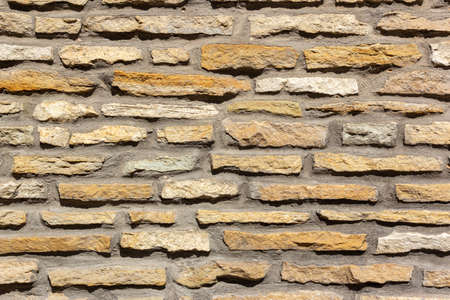 Horizontally aligned limestone wall stone blocks. Colorful texture of the limestone walls. Limestone wall texture, built structure, building exterior, construction industryの写真素材