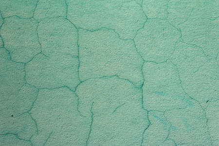 The old cracked green paint on a wall surface. Peeling paint on wall seamless texture. Pattern of...