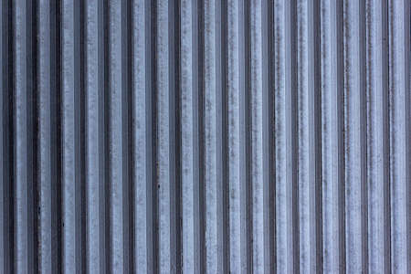 Corrugated sheet metal, badly painted with gray paint for background. Metal corrugated roofing sheet.Painting of metal surfaces for rust control Abstract background for sites and layouts. Iron fenceの写真素材