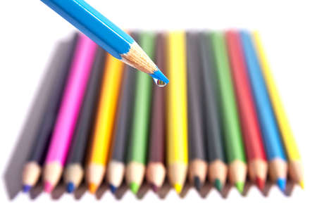 Colored pencils organized in a nice way on a while isolated background with a macro drop.