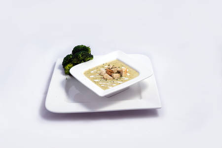 Hero Shot of a Broccoli Soup with bread crumbs, oregano on a minimal white background with a 45 degree front facing angleの写真素材