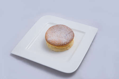 A low contrast Hero Shot of a pan cake on a plate, on a minimal white background with a diagonal 60 degree angleの写真素材