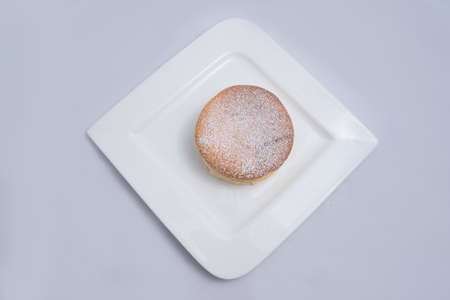 A low contrast Hero Shot of a pan cake on a plate, on a minimal white background with a diagonal 60 degree angleの写真素材
