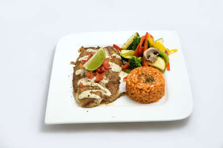 A Hero shot of a grilled fish fillet gratini with vegetables & lentils on the side, on a white plate, minimal background with a 60 degree front facing perspective.の写真素材