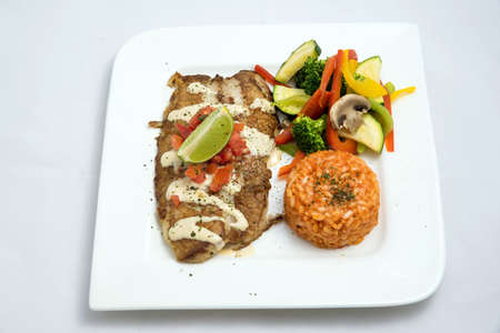 A Hero shot of a grilled fish fillet gratini with vegetables & lentils on the side, on a white plate, minimal background with a 60 degree front facing perspective.の写真素材