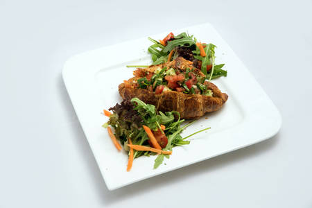 A low contrast Hero shot of a breakfast platter with vegetable-filled croissant with vegetables- carrot, tomato, lettuce on a minimal white background with a 30 degree angle from diagonal perspective.の写真素材