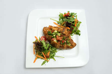 A low contrast Hero shot of a breakfast platter with vegetable-filled croissant with vegetables- carrot, tomato, lettuce on a minimal white background with a 30 degree angle from diagonal perspective.の写真素材