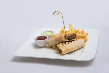 A low contrast Hero shot of a beef wrap sandwich with samurai & alger sauce and fries on the side, on a minimal white background with a 45 degree angle from front zoomed in perspectiveの写真素材