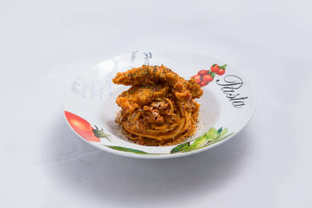 A low contrast Hero shot of chicken curry with pasta noodles in a plate with minimal white background with 60 degree angle from front perspectiveの写真素材