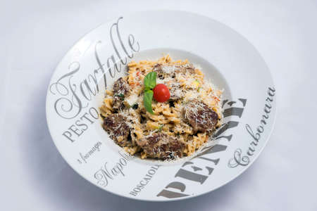 A high contrast Hero shot of a Meat & sprinkled Cheese Pasta, on a minimal white background with a 90 degree angle from zoomed vertical perspectiveの写真素材