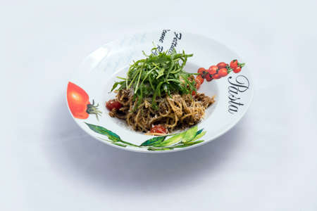 A high contrast Hero shot of a Tuna pasta /  tuna tapenade with olives, tomato & salad, on a minimal white background with a 60 degree angle from zoomed frontal perspectiveの写真素材