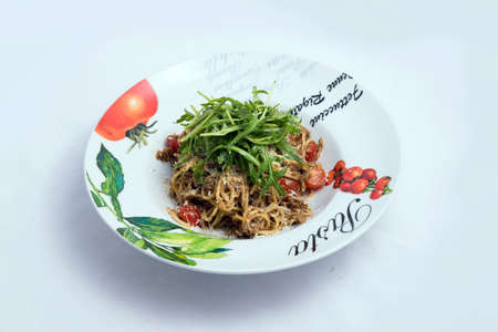 A low contrast Hero shot of a Tuna pasta /  tuna tapenade with olives, tomato & salad, on a minimal white background with a 60 degree angle from zoomed frontal perspectiveの写真素材