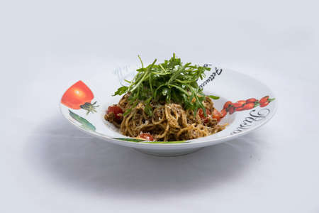 A high contrast Hero shot of a Tuna pasta /  tuna tapenade with olives, tomato & salad, on a minimal white background with a 90 degree angle from zoomed vertical perspectiveの写真素材
