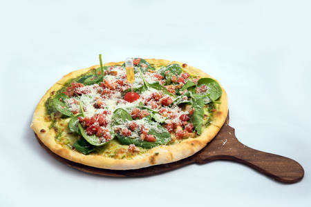 "A high contrast Hero shot of a Bruschetta Al Pesto Spinaci Pizza, on a minimal white background with a 60 degree angle from zoomed out slant perspective. Incredients include Bruschetta bread, Pesto sauce & spinach. Bruschetta -is Toasted italian bread drenched in oil.
Pesto is Italian green sauce made from basil leaves, parmesan cheese, pine nuts, and olive oil."の写真素材