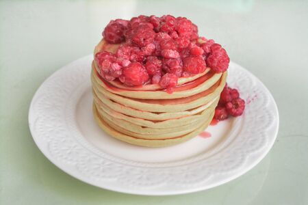 Breakfast pancakes garnished with stewed raspberries