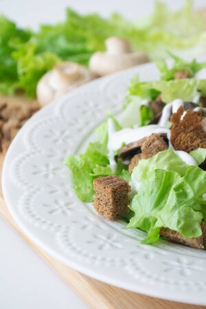Vegetarian version of classic Caesar salad with mushrooms instead of chicken, croutons, lettuce, parmesan cheese and dressing sauceの写真素材