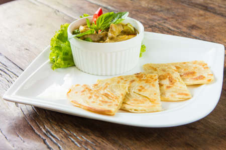 Red curry chicken soup served with roti, thai cuisine.の写真素材