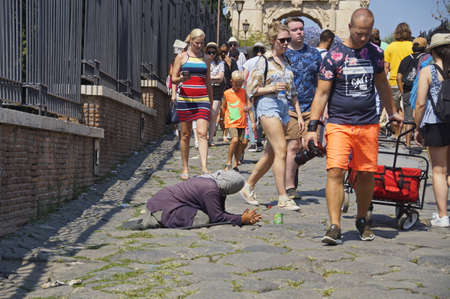 a refugee asks for alms on the sidewalk in Romeのeditorial素材