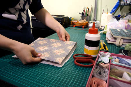 the process of handmade creating of the diary from special scrapbooking paper, paper flowers and...