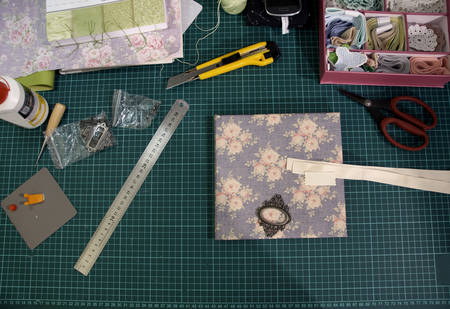 the process of handmade creating of the diary from special scrapbooking paper, paper flowers and...
