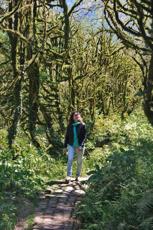 photo of a girl walking along the trail path through boxwood forestの写真素材