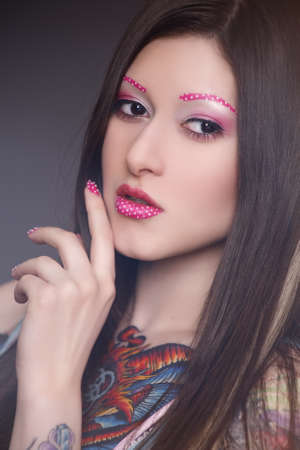 Tattoo model with bright make-upの写真素材