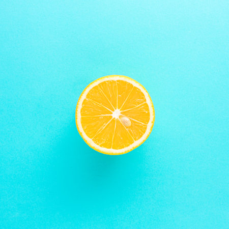A beautiful fresh lemon, cut in half, on a light pastel blue background. Flat lay.の写真素材