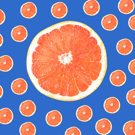 Fresh red grapefruit citrus  cut in half pattern on a blue background. Flat lay.の写真素材
