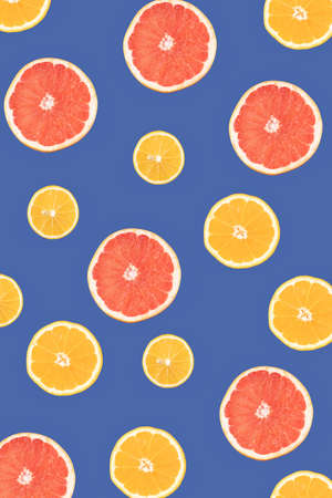 Lemon, orange and grapefruit on a blue background, cut in half. Flat lay colorful pattern.の写真素材