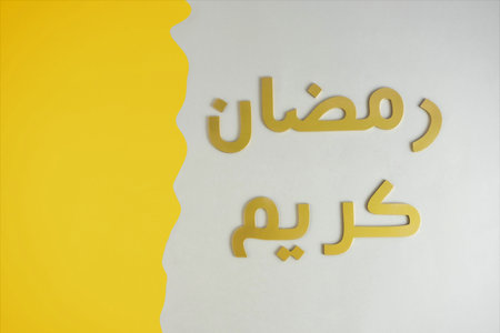 Ramadan Kareem creative greeting card made of carved and painted golden letters on a gray and yellow background. Minimal Ramadan Mubarak design.の写真素材