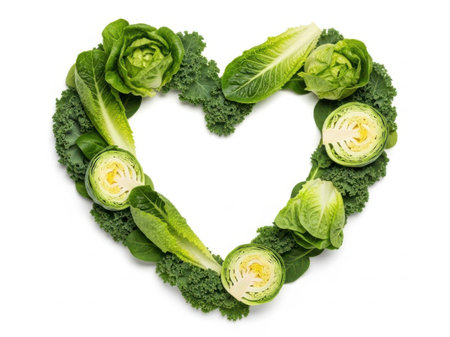 A beautifully arranged heart shape made of various fresh green vegetables, including cabbage, kale, and Brussels sprouts, symbolizing health and love.の素材