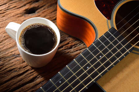 coffee cup and guitar on wooden tableの写真素材
