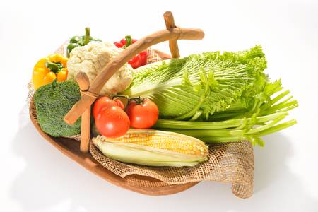 fruits and vegetables in wooden basket on whiteの写真素材